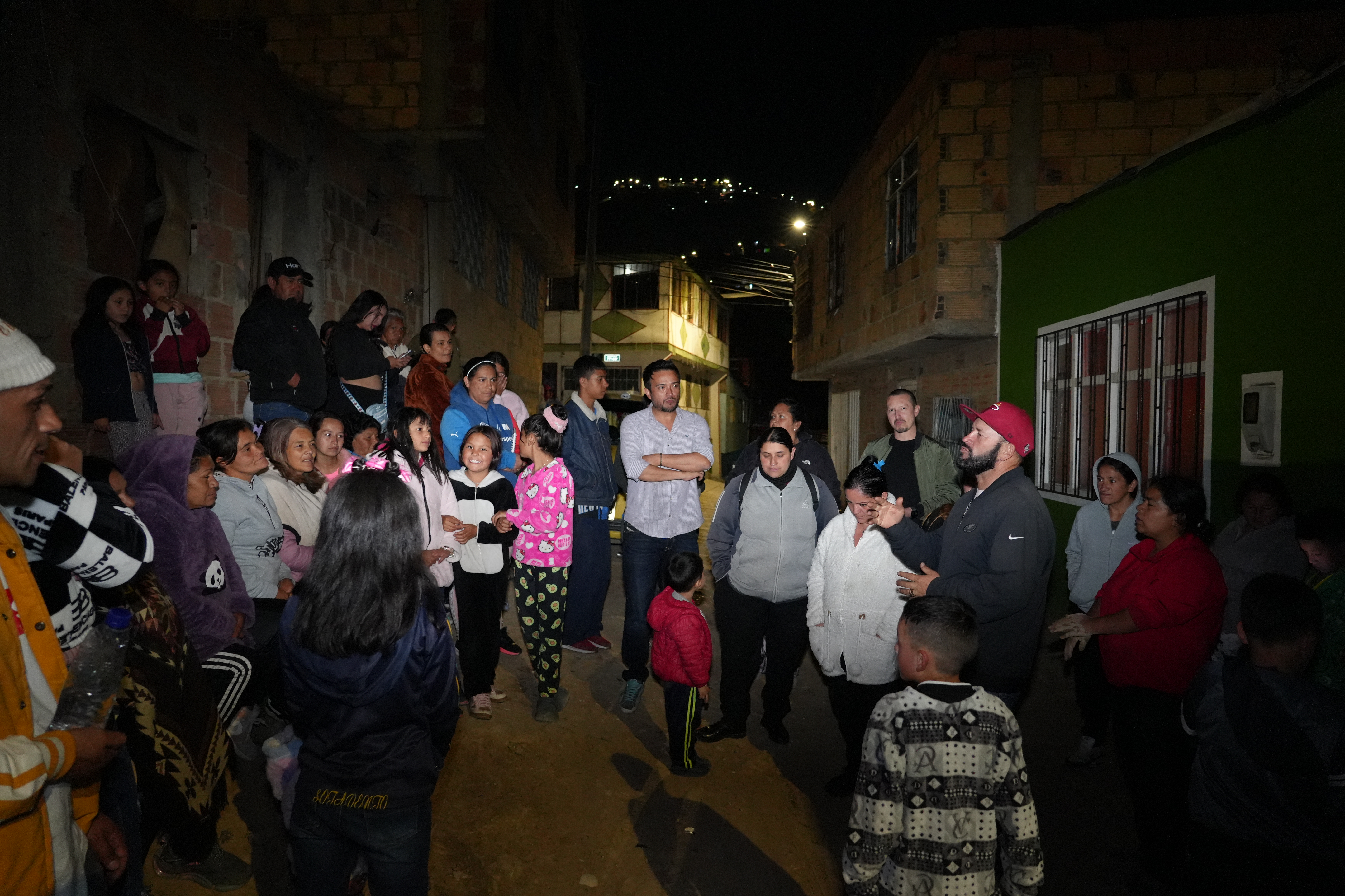A view of city buildings with mountains in the background under a cloudy sky.