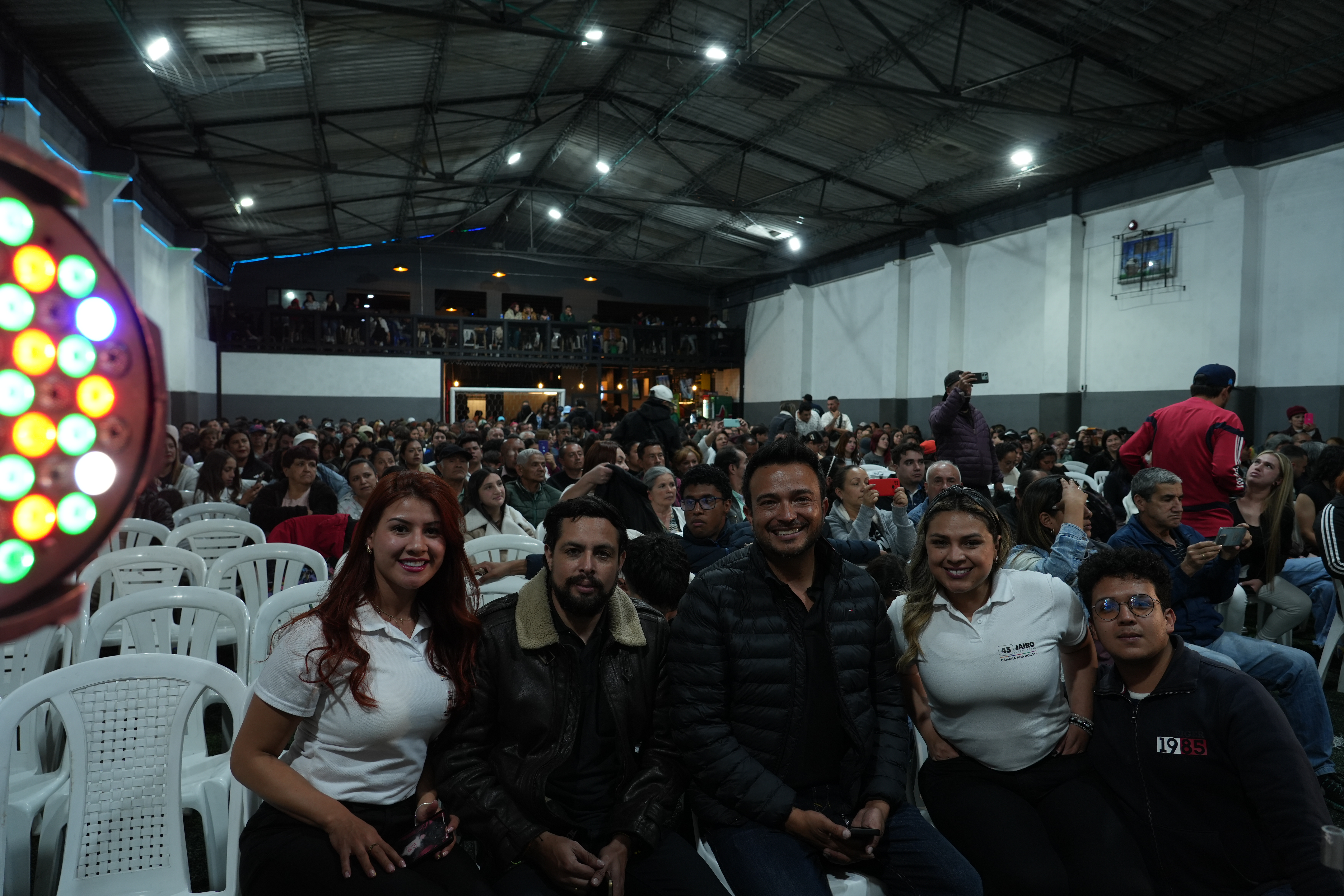People raising hands in a town hall meeting